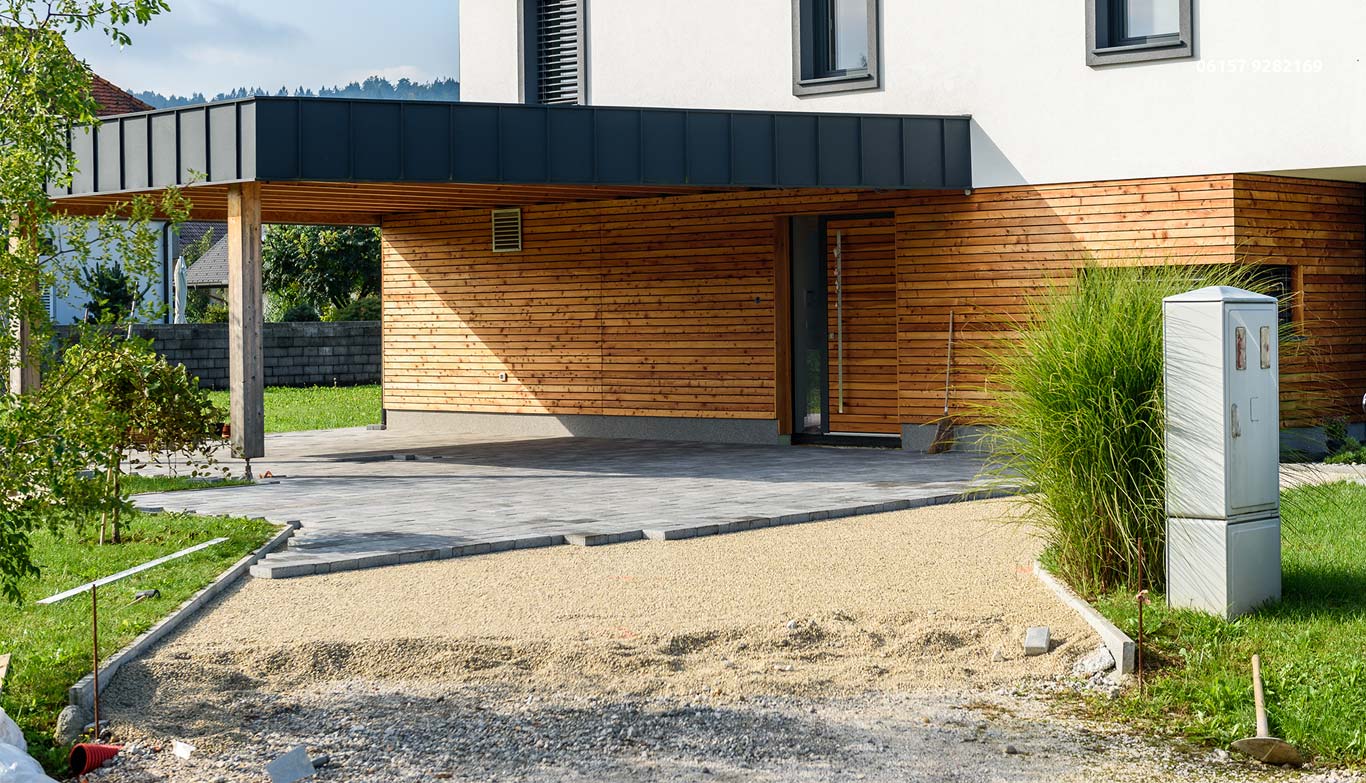 Ein Weg aus grauen Fliesen wird im Außenbereich eines Hauses neu angelegt